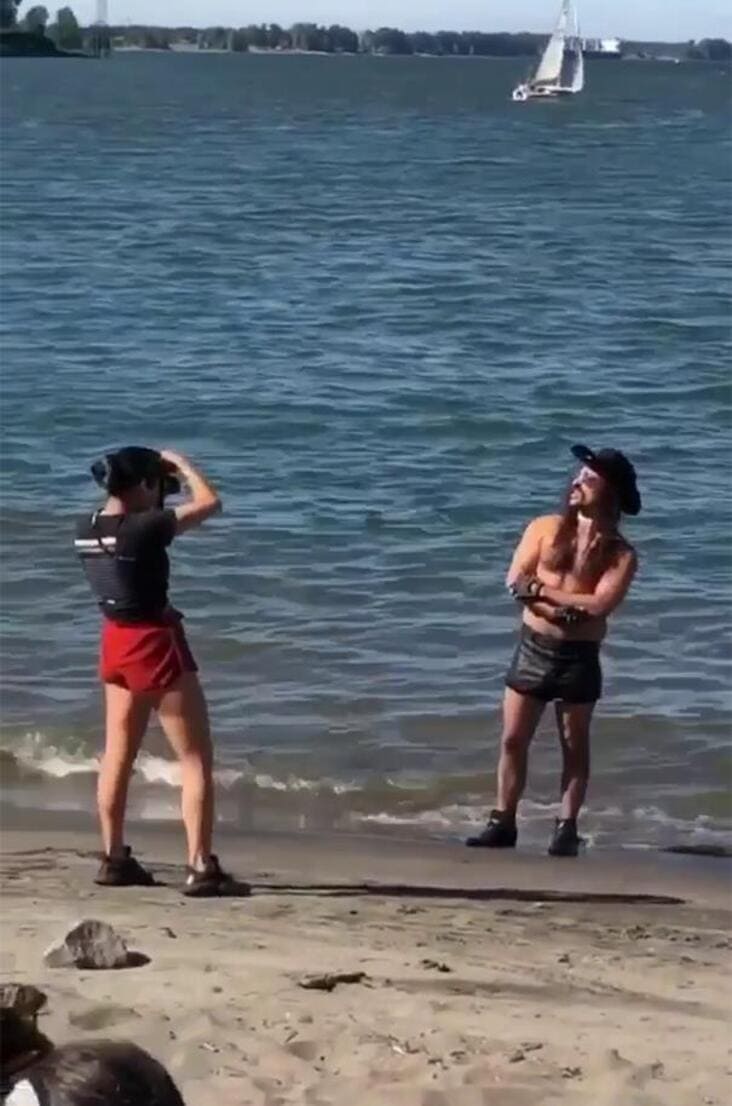 An influencer getting busted doing a very strange and cringe cowboy photoshoot on a beach.