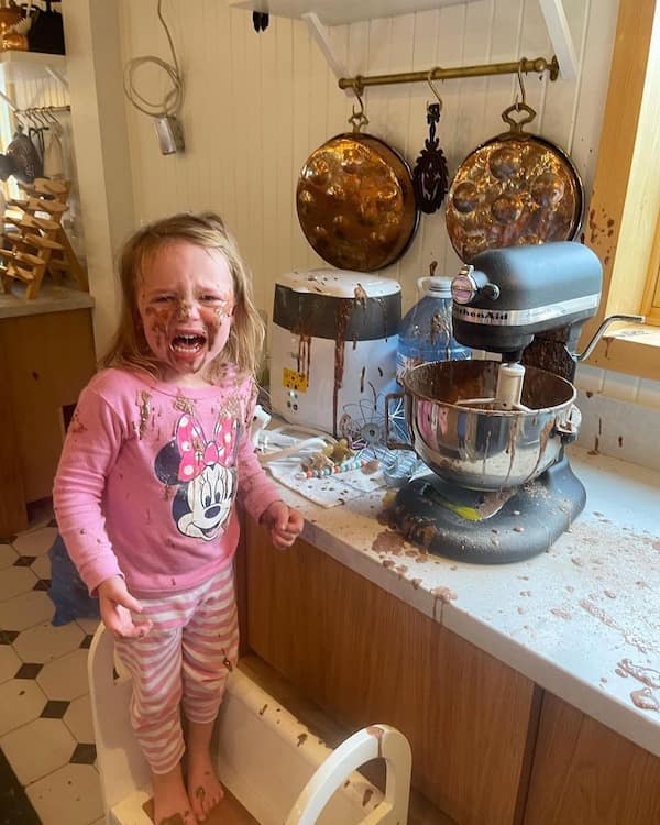 A little girl crying after kids breaking things caused a chocolate explosion with a stand mixer.