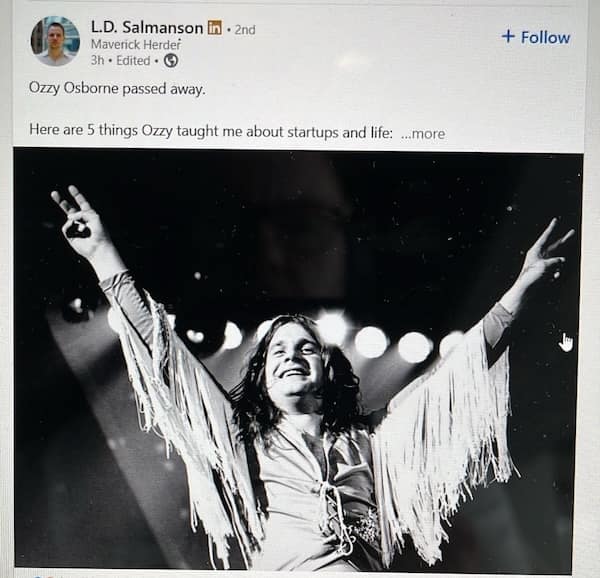 Black and white photo of Ozzy Osbourne with arms raised on stage