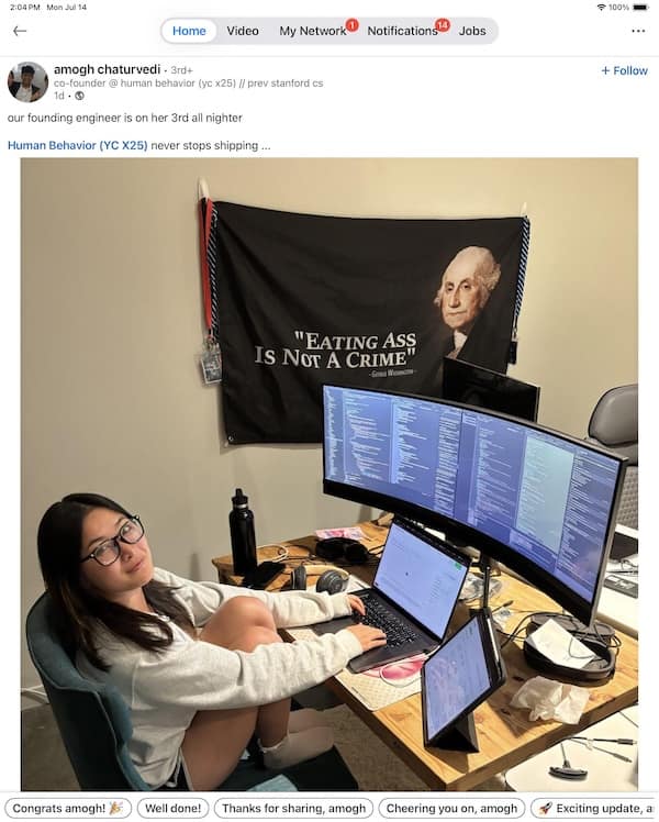 Woman at desk coding with large monitor and George Washington flag