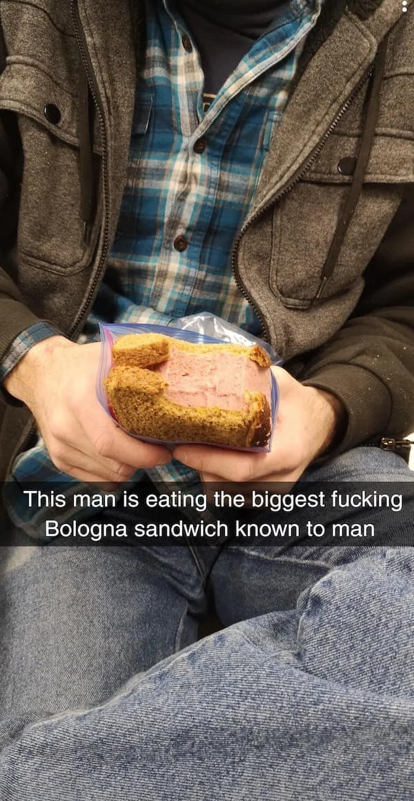 Close-up of hands holding a massive bologna sandwich stuffed in a zip bag; caption marvels at its size.