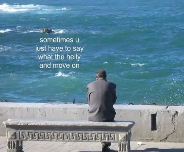 Man in a suit sitting alone on a concrete bench facing the ocean, text overlay says, “sometimes u just have to say what the helly and move on.”