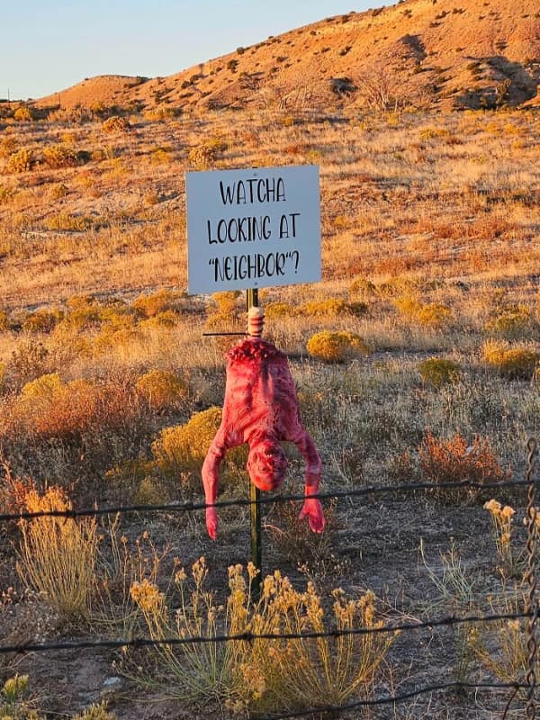 A terrifying passive aggressive neighbour "note" using a creepy upside-down bloody scarecrow.