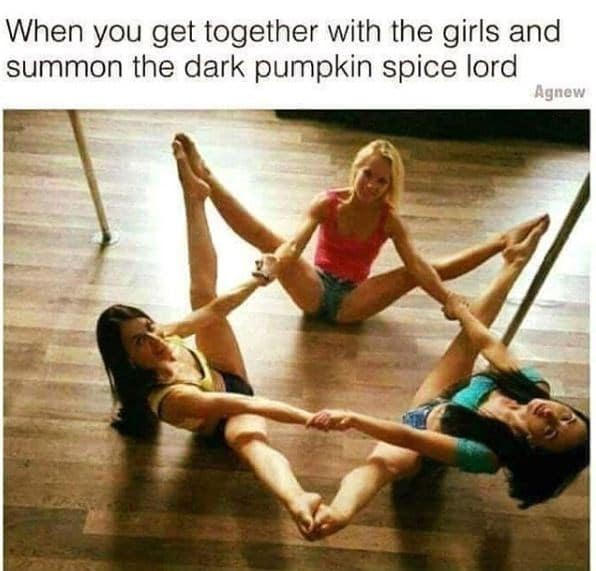 Three women on a hardwood floor link hands and feet in a star shape as a joke about summoning a pumpkin spice lord.