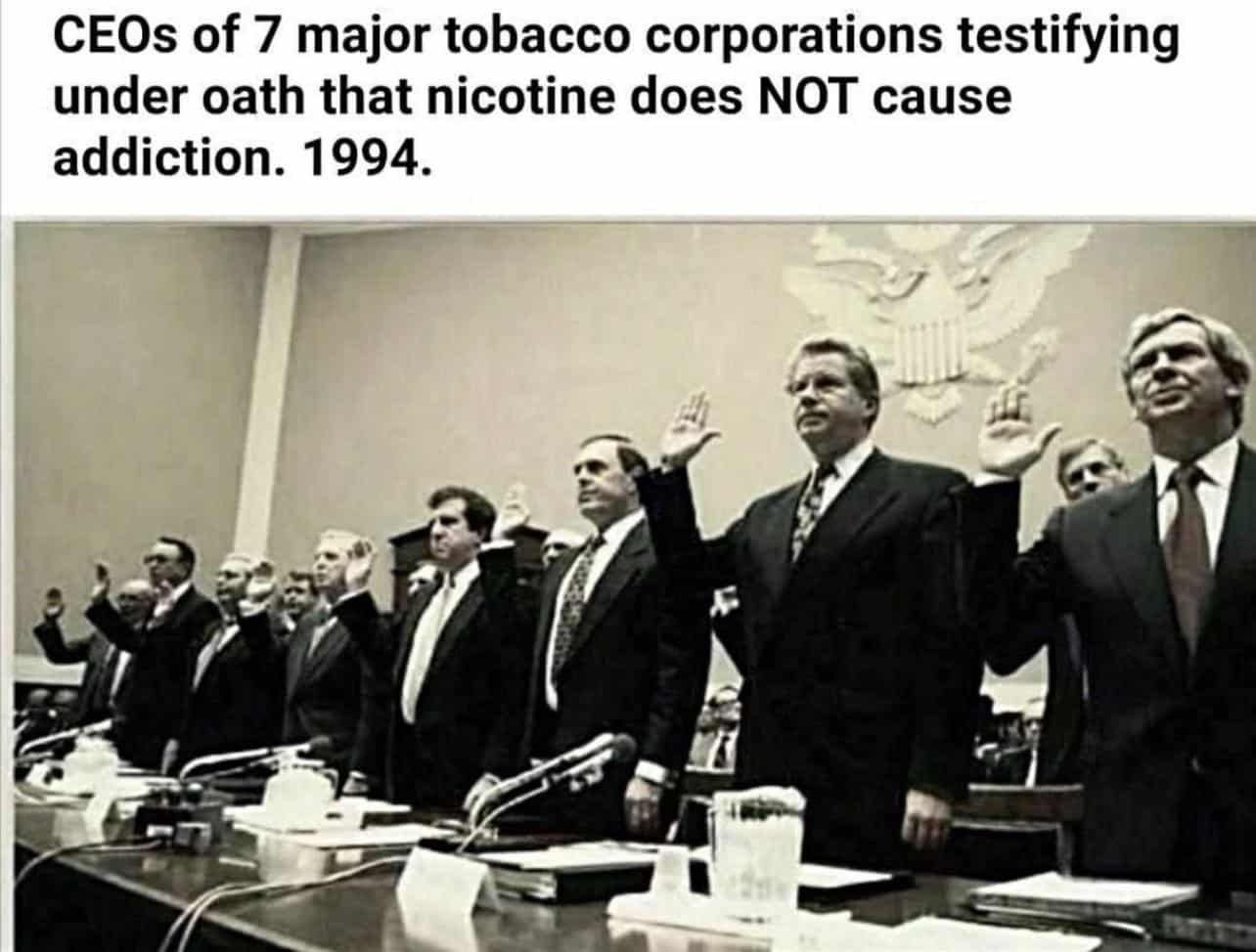 A photo from 1994 of seven tobacco CEOs swearing under oath that nicotine is not addictive.