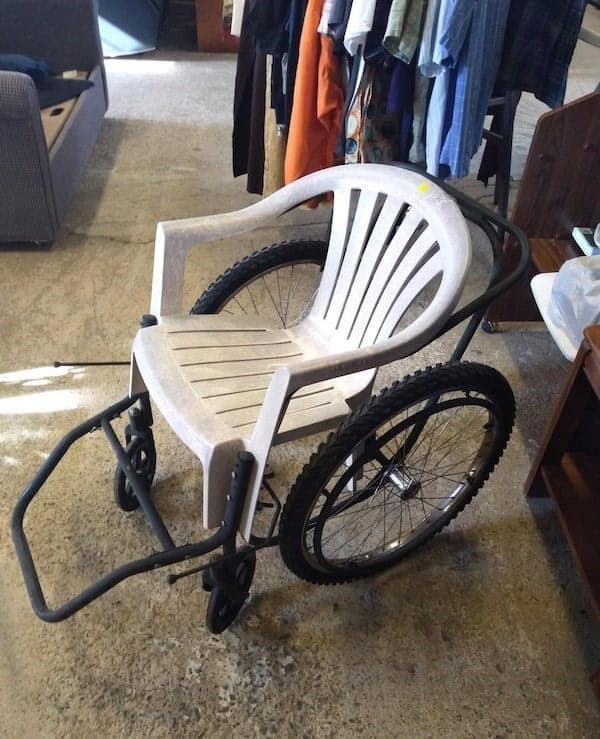 A DIY wheelchair made from a plastic chair and bike wheels, a true redneck engineering marvel.