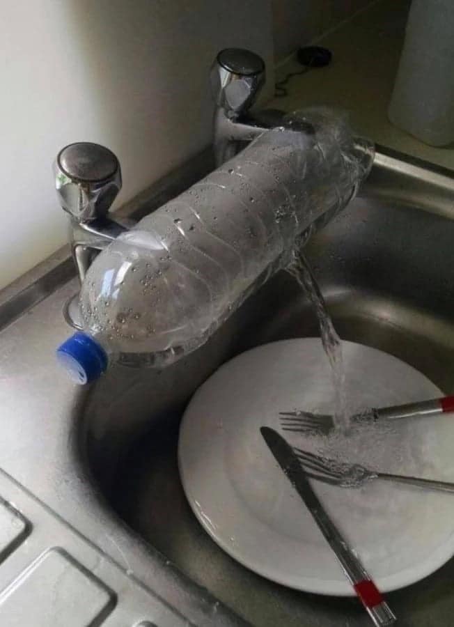 A DIY faucet extender made from a water bottle, an example of redneck ingenuity at the sink