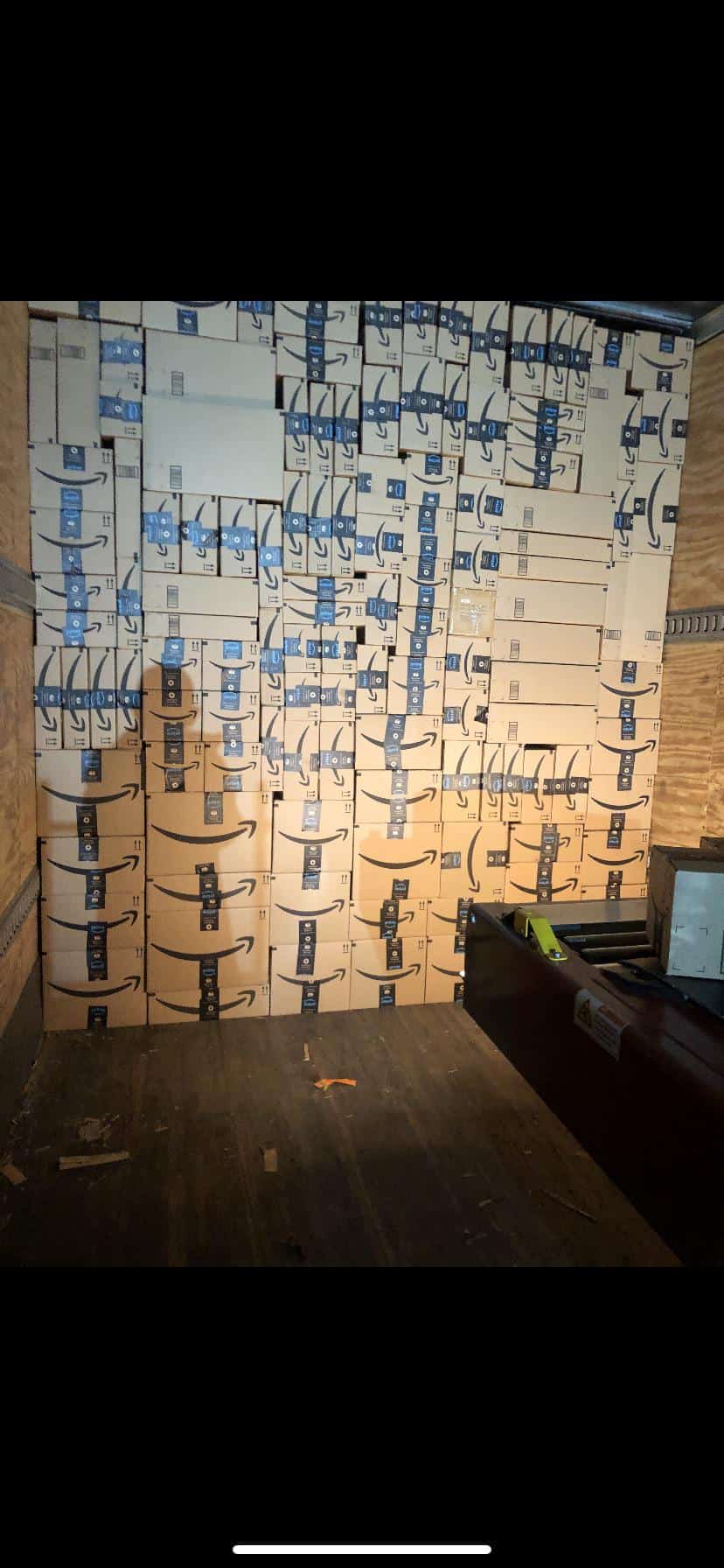 Wall of Amazon boxes stacked flush like Tetris inside a truck