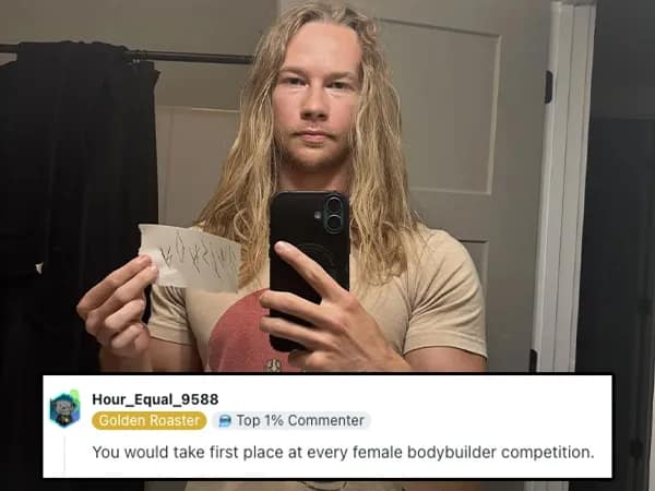 Long-haired muscular man mirror selfie; roast compares him to a women’s bodybuilding champ.