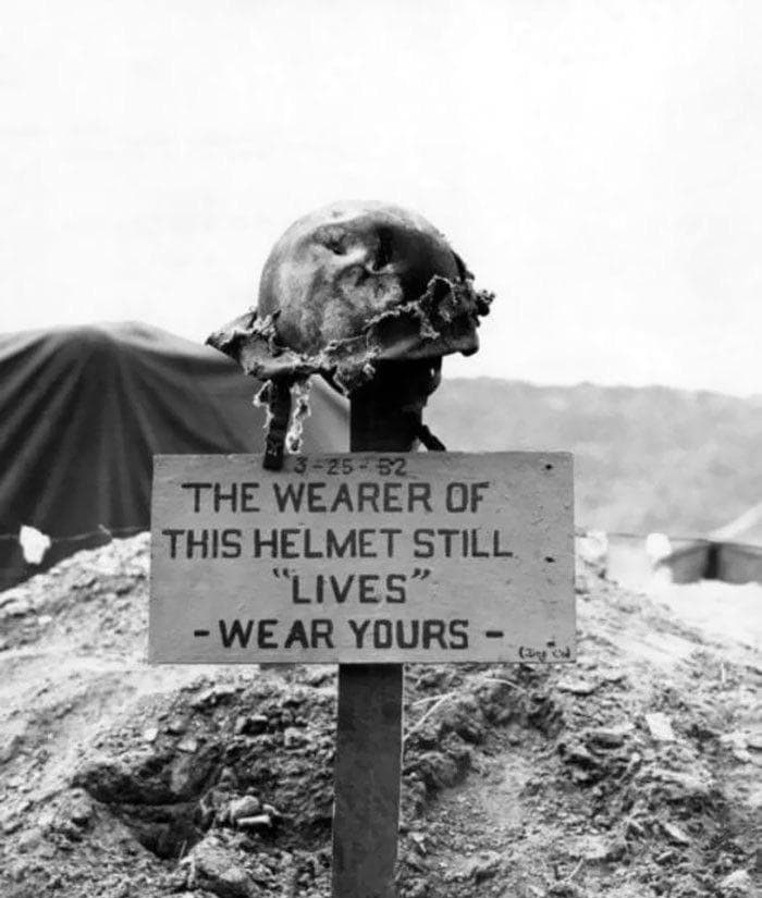Battlefield sign with helmet warns “The wearer still ‘lives’”