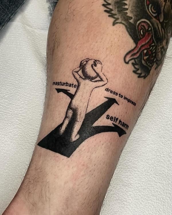 A tattoo of a distressed cartoon figure standing at a three-way intersection labeled “masturbate,” “dress to impress,” and “self harm.”