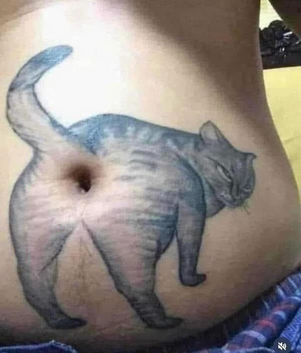 A tattoo of a cat with its rear pointed toward the viewer, aligned with the person's belly button.