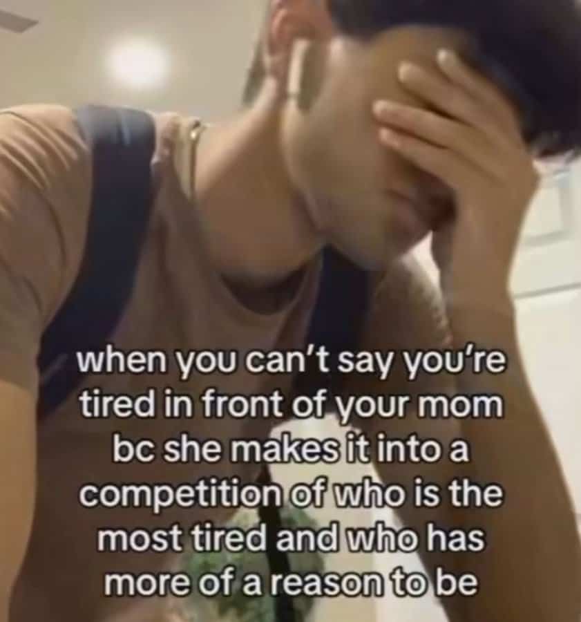 Young man covering face in frustration, relatable tired meme