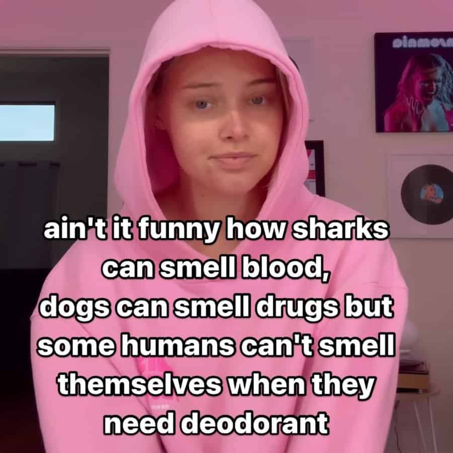 Woman in pink hoodie with deadpan face and hygiene joke