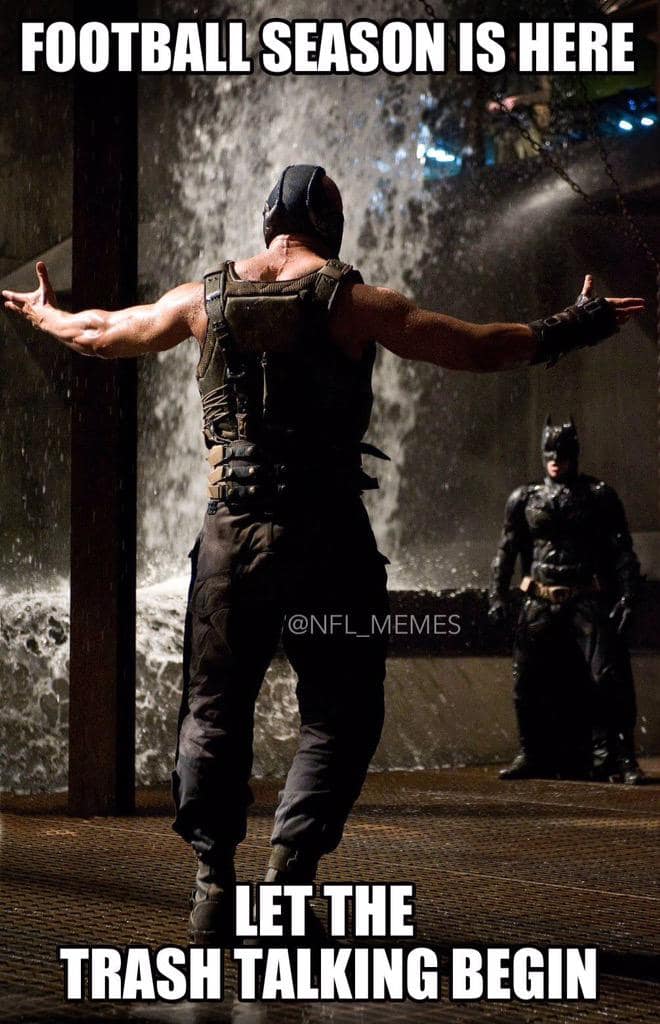 Movie still of a masked muscular figure standing arms wide in a cavernous setting as a hero watches from afar; bold caption announces football season and trash talk.