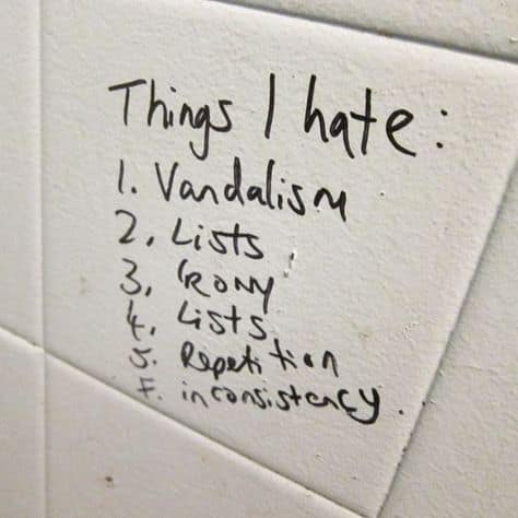A clever and funny handwritten list of "Things I hate" on a bathroom wall, which ironically includes the concepts of vandalism, lists, and irony itself.