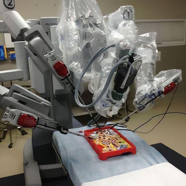 A blursed image of a Da Vinci surgical robot playing the classic board game "Operation."