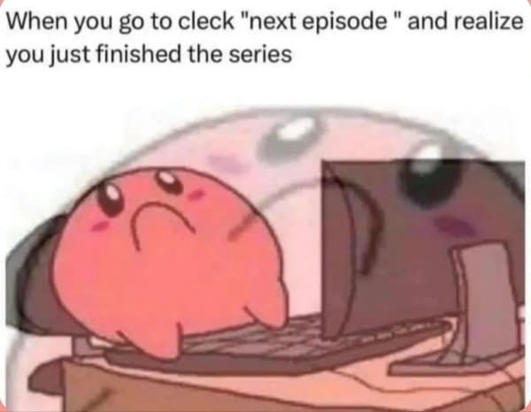 Pink round character slumps at a desk after clicking “next episode,” realizing the series is over.