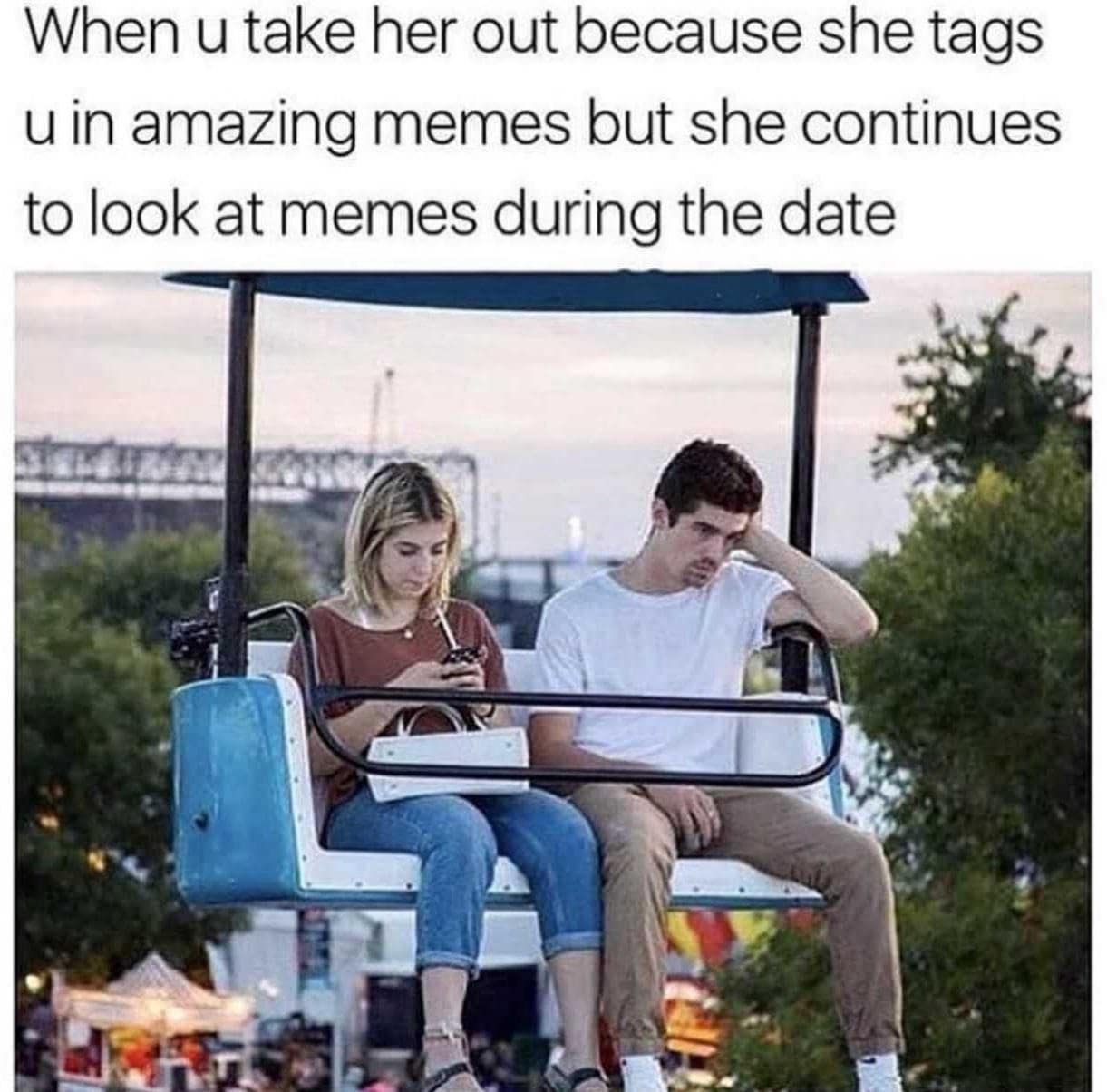 Couple on a skyride; woman engrossed in her phone while her date looks bored