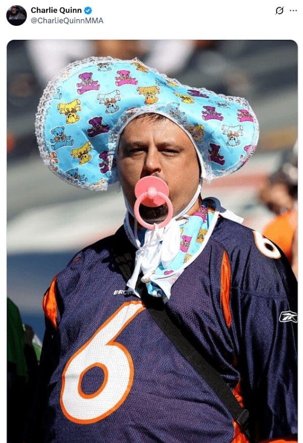 A funny picture of a grown man and dedicated Denver Broncos fan dressed as a baby at a football game.