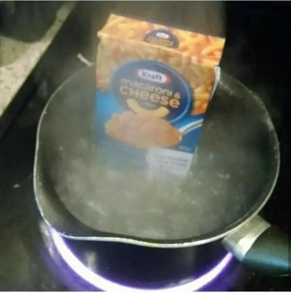 A cursed image of someone boiling an entire unopened box of Kraft Macaroni & Cheese.