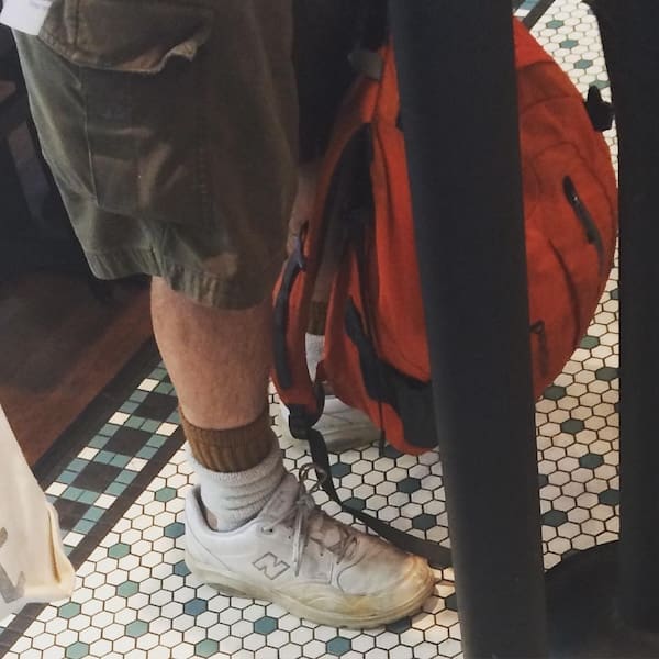 A classic dad fit featuring dirty white New Balance sneakers with slouchy socks and casual cargo shorts.