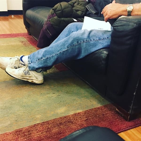 The ultimate relaxation dad fit: comfortable light-wash jeans and a pair of trusty white New Balance sneakers.