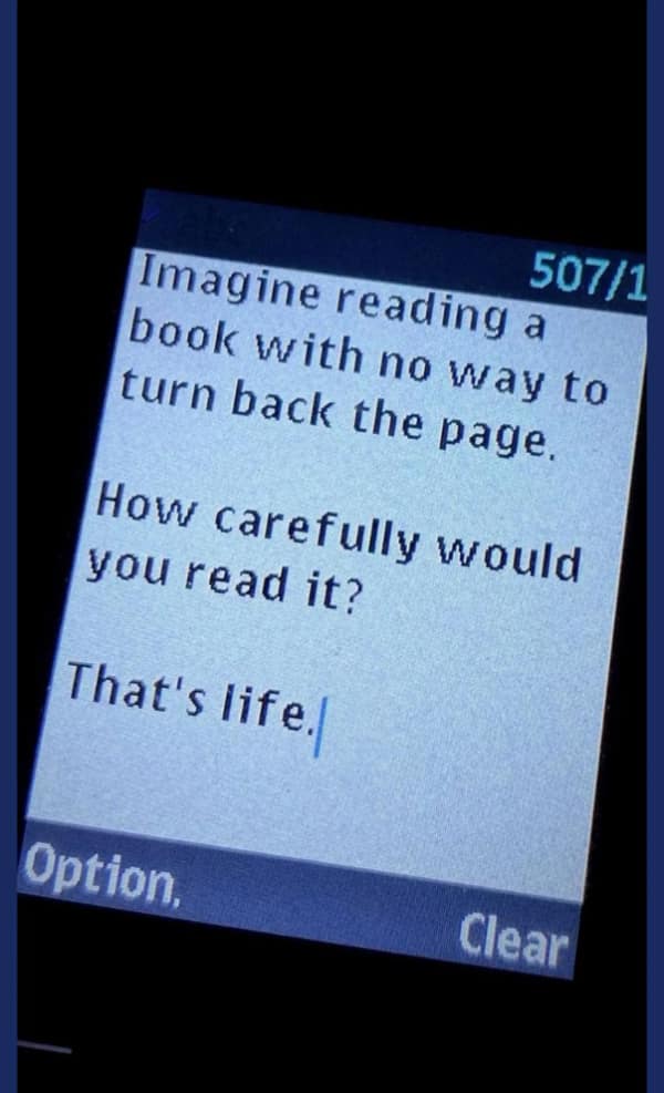 A photo of a text message on an old flip phone that has a philosophical metaphor about life being like a book you can't re-read.