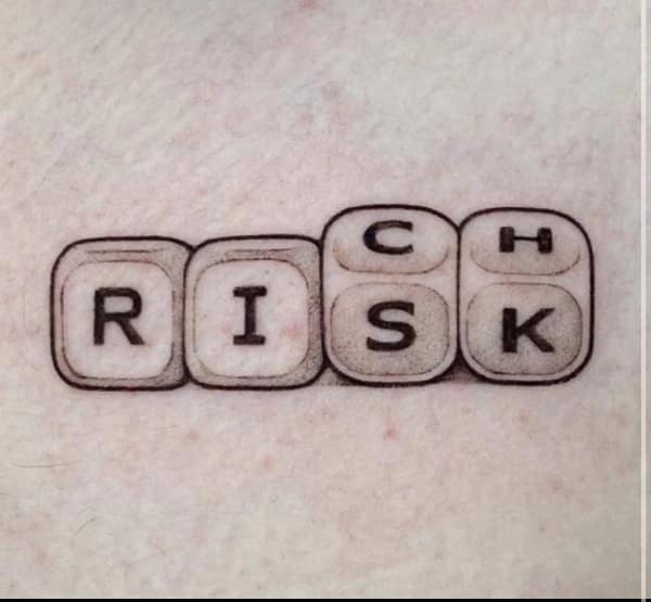 A very clever and intricate tattoo of the word "RISK" where the letters for the word "RICH" are also hidden vertically within the design.