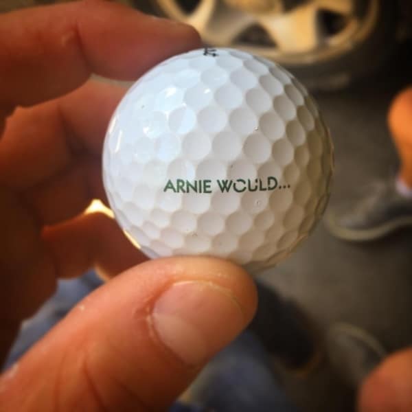 A found golf ball with the classic phrase "ARNIE WOULD..." printed on it, referencing the golf legend Arnold Palmer.