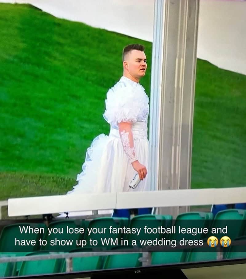 Man in a white wedding dress at a stadium as last-place punishment in a fantasy football league.