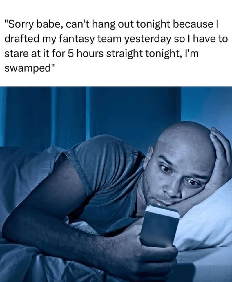 Man in bed staring at his phone with a long caption about staring at his fantasy roster after the draft.