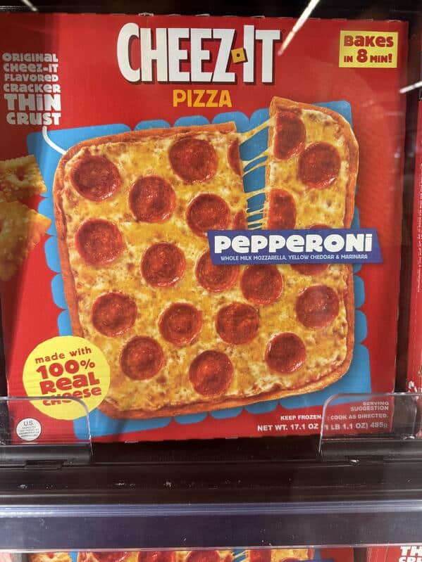 A funny food product of a frozen pepperoni pizza with a thin crust made out of a giant Cheez-It cracker.