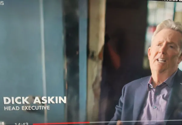 A funny screenshot from a documentary of a head executive with the very unfortunate and hilarious name "Dick Askin."