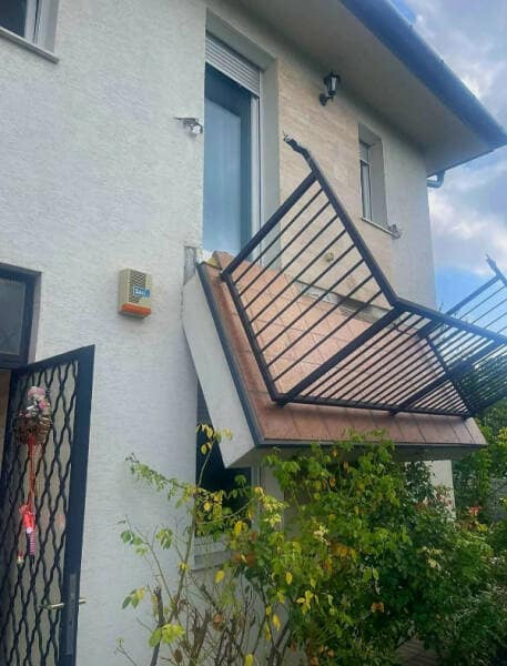 A funny meme-worthy picture of a catastrophic failure where a balcony has fallen off the side of a house.