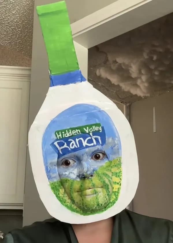 A cursed and hilarious picture of a person with their face painted to look like a bottle of ranch dressing.