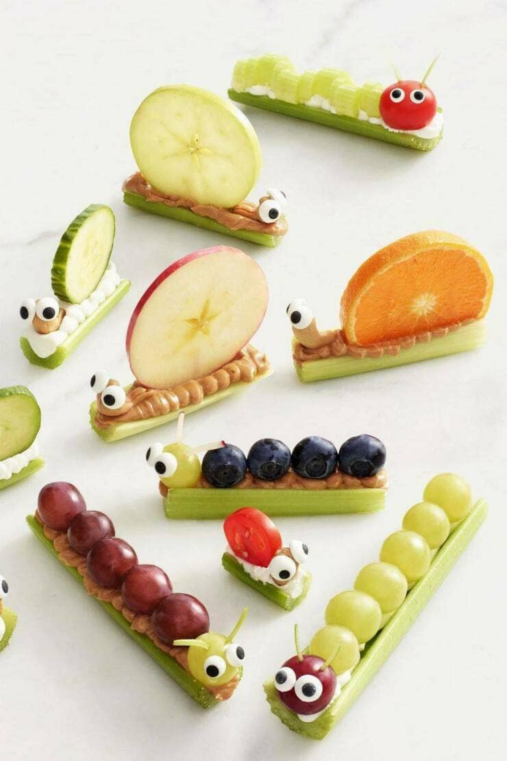 : A photo of cute and incredibly creative healthy snacks for kids, made from celery, fruit, and peanut butter to look like little snails and caterpillars.