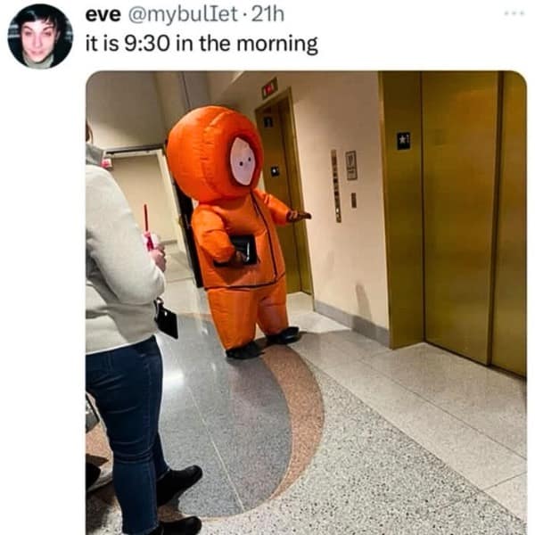 A person in a large, inflatable Kenny from South Park costume waiting for an elevator at 9:30 AM.