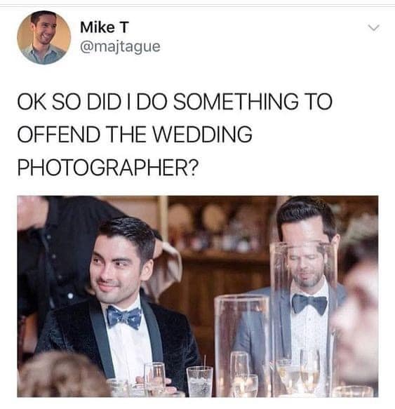 A hilarious tweet from a man who is wondering if he did something to offend the wedding photographer, as his head is completely obscured by a glass vase in a professional wedding photo.