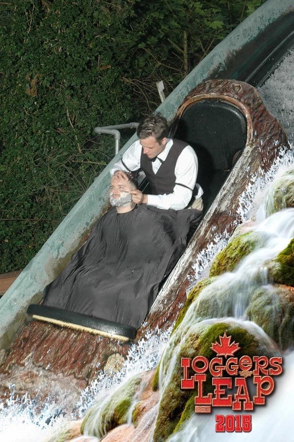 A hilarious rollercoaster photo of a man dressed as a barber giving another man a full shave on a log flume.