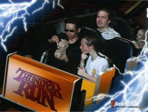 A funny rollercoaster pic of two people calmly playing a game of rock-paper-scissors in the middle of a dark ride.