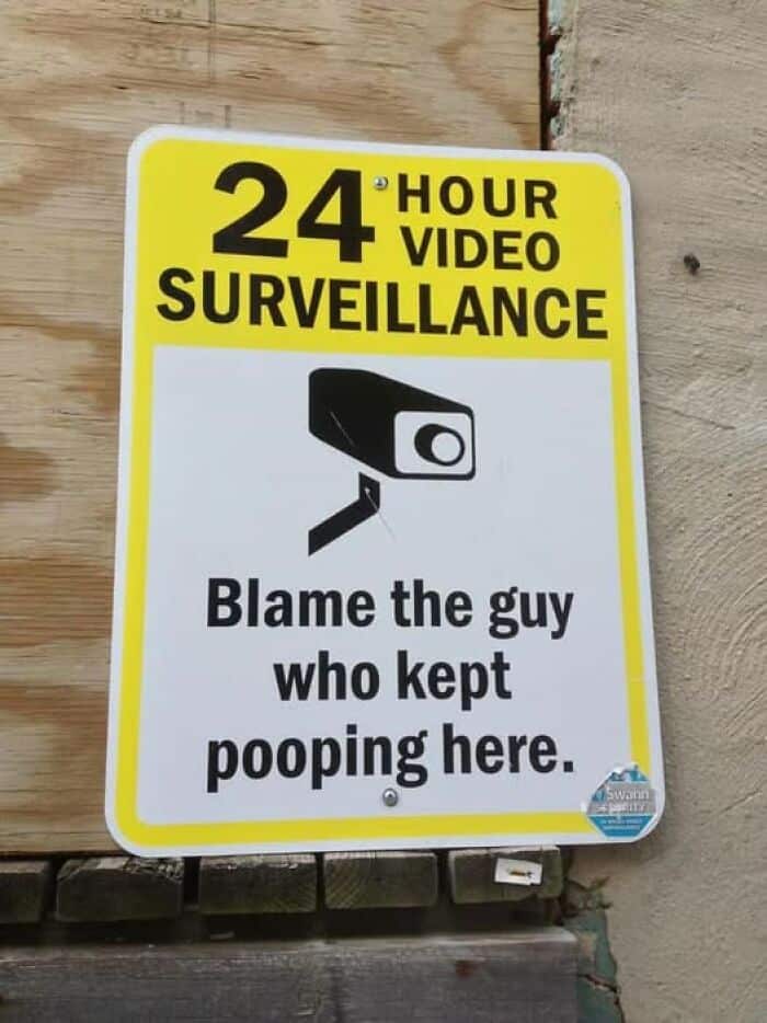 A hilarious sign for 24-hour surveillance that adds, "Blame the guy who kept pooping here."