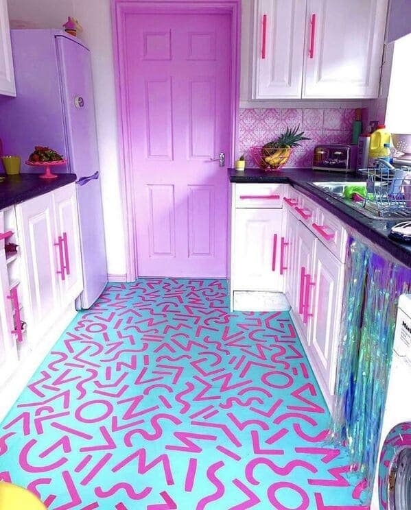 Bright pink and lavender kitchen with a teal floor covered in squiggly magenta shapes.