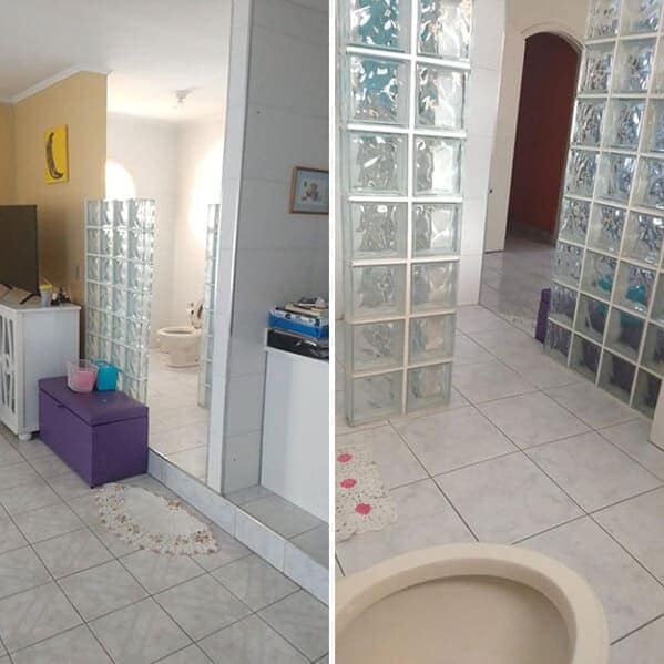 Living area with clear glass-block walls offering a direct view into a bathroom.