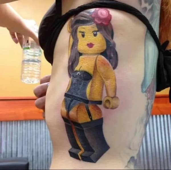 Photo of a realistic tattoo of a curvy LEGO minifigure in lingerie on someone’s ribcage