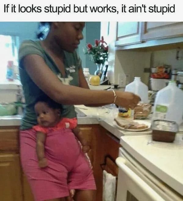 Mom cooking while baby sits tucked inside the front of her shorts; caption: “If it looks stupid but works…”