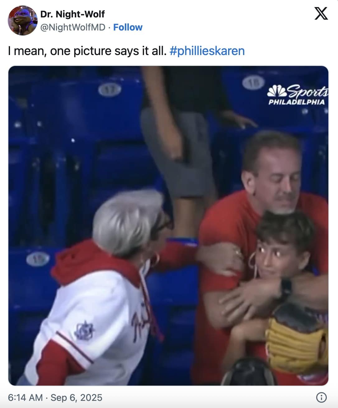 Tweet with a photo of a gray-haired woman in a Phillies hoodie leaning toward a boy clutching a glove while a man holds him back; caption: “one picture says it all.”