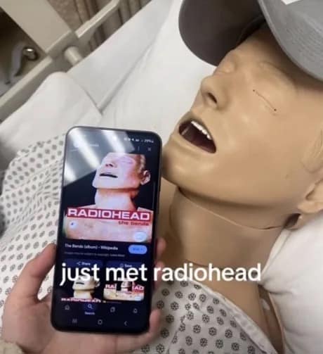 Phone shows The Bends cover next to a mannequin with the same open-mouth pose; caption “just met radiohead.”