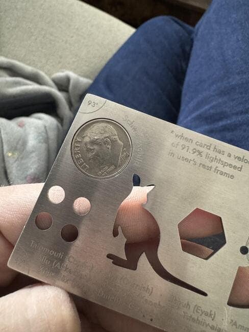 A satisfying perfect fit of a United States dime coin fitting exactly into a circular space on a multi-tool card.