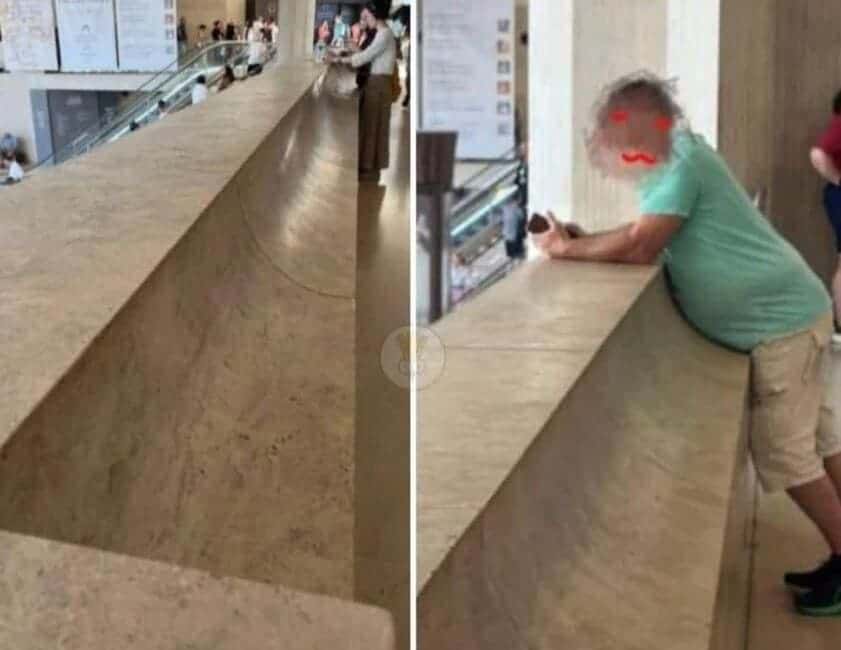 A man's large belly fitting perfectly into the curved, ergonomic design of a stone railing at a museum.